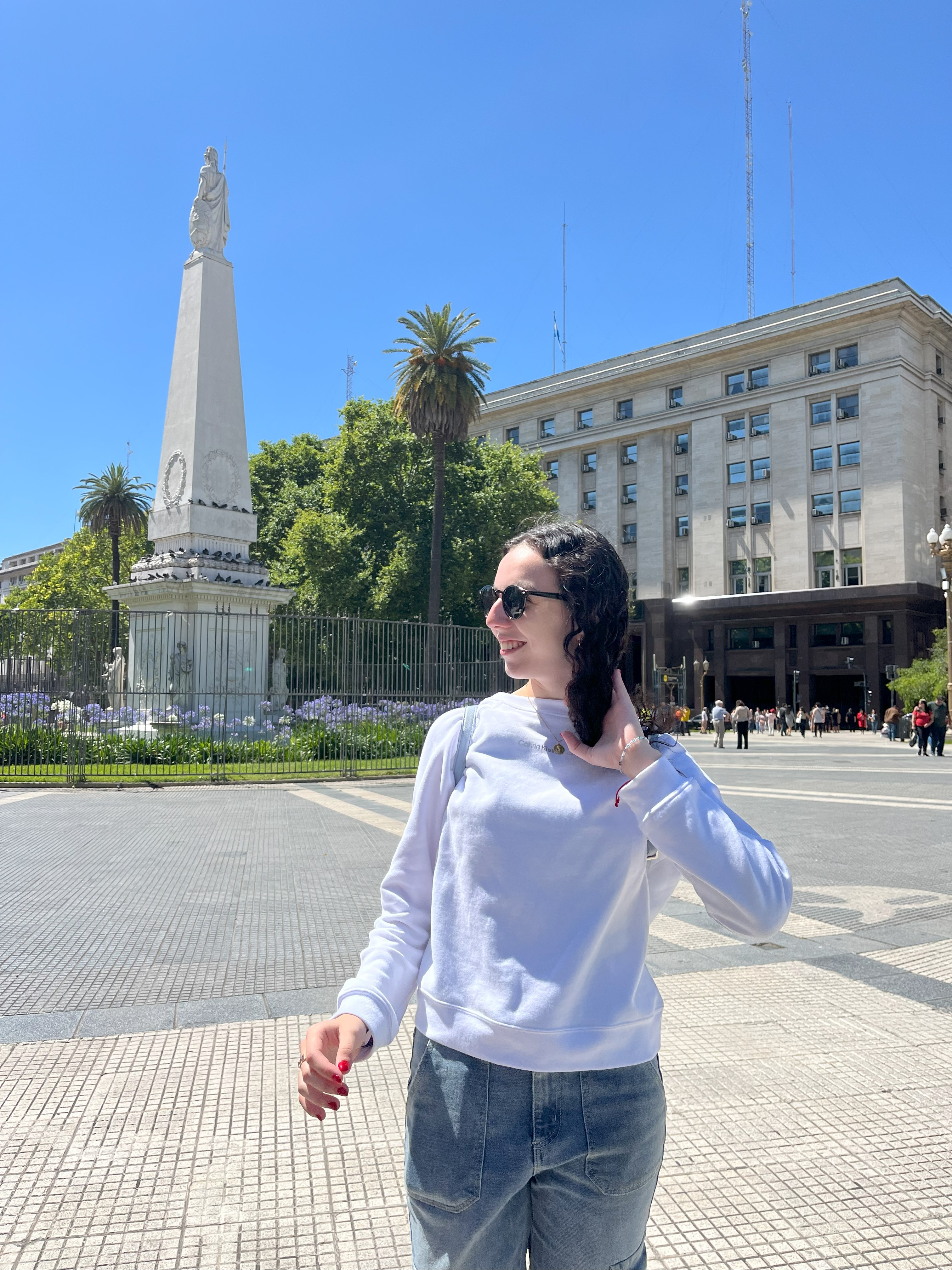 Martina sonriendo frente a la pirámide donde están pintandos los pañuelos de las Madres, minutos antes de que un hombre comenzara a gritarnos.
